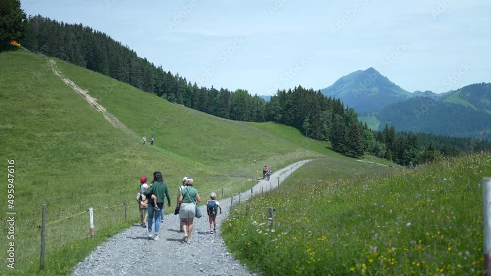 People hiking outside in beautiful green path overlooking mountains People hiking outside in beautiful green path overlooking mountains