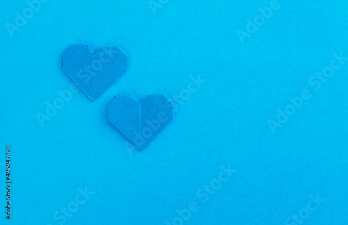 Blue origami hearts on blue background