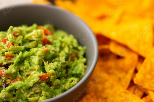 Mexican corn chips nachos with avocado red pepper sauce, top view