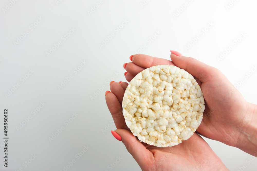 Female hand holding rice cracker. Fit diet, healthy food concept Female hand holding rice cracker. Fit diet, healthy food concept