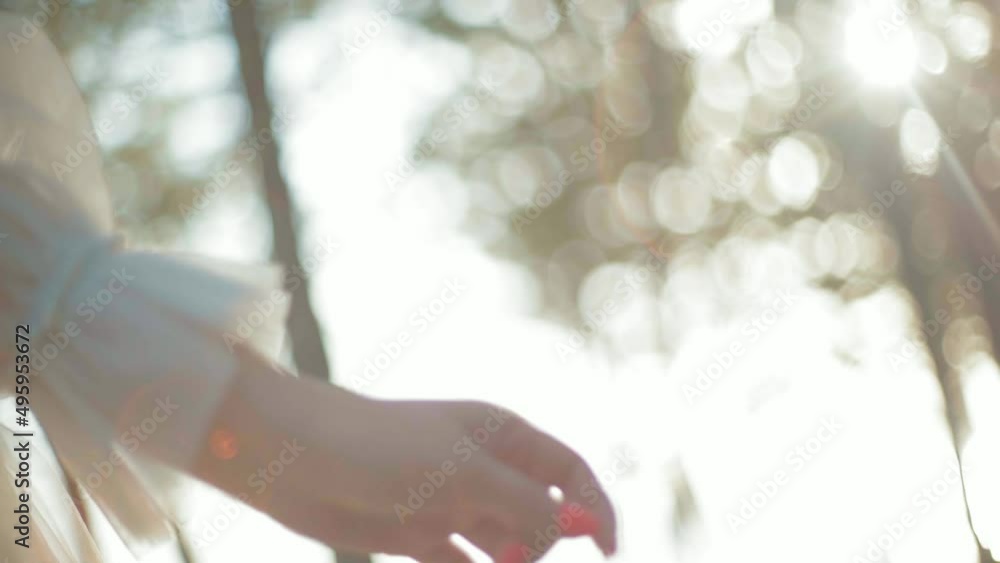 The girl holds the dress and then lets go, against the backdrop of sunny glare, slow motion The girl holds the dress and then lets go, against the backdrop of sunny glare, slow motion