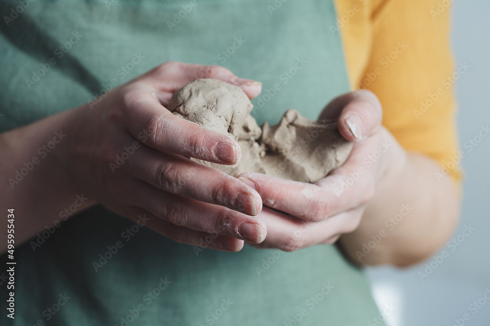 Wet raw clay in woman potter hands