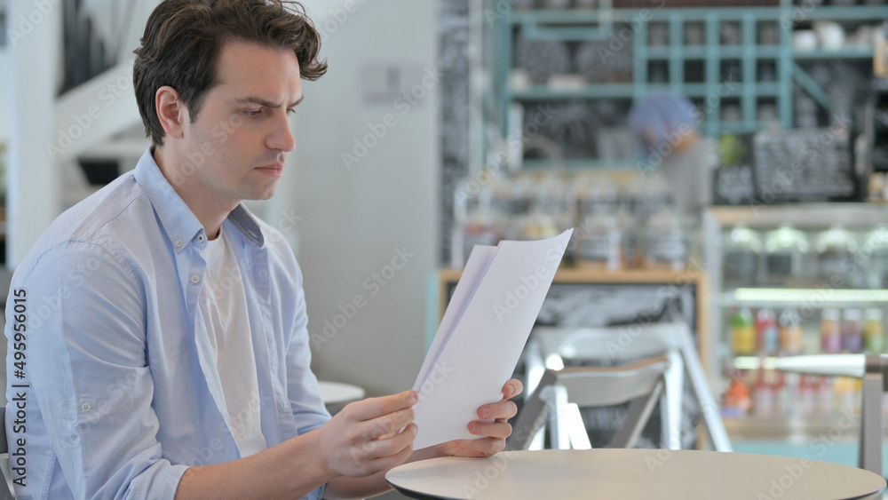 Creative Man Celebrating Success while Reading Documents Creative Man Celebrating Success while Reading Documents