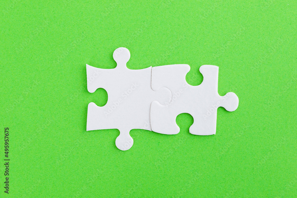 Two puzzle pieces on green background Two puzzle pieces on green background