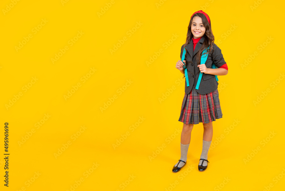 happy child in school uniform with backpack on yellow background, copy space, school happy child in school uniform with backpack on yellow background, copy space, school