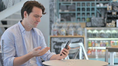 Creative Man Loss on Smartphone in Cafe