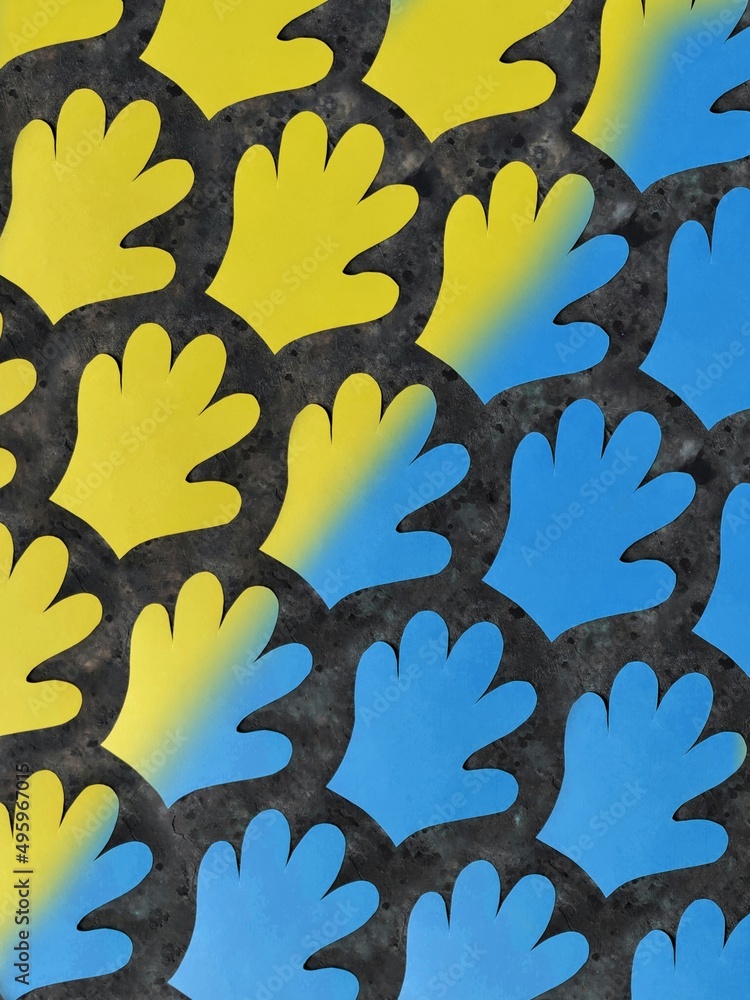 Naklejka premium Pattern of yellow and blue paper palms on a black concrete background