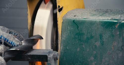 sharpen drill bits on a bench grinder, close up.