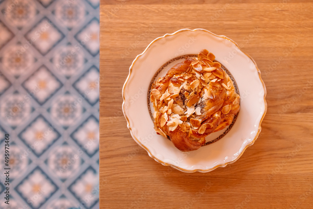 Breakfast time. Sweet cake with cream, almonds on a beautiful plate on a wooden table Breakfast time. Sweet cake with cream, almonds on a beautiful plate on a wooden table