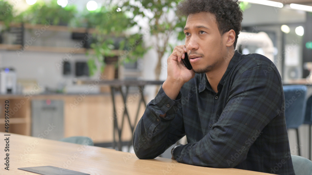African American Man Talking on Smartphone at Work African American Man Talking on Smartphone at Work