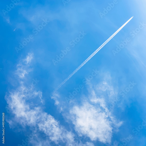 Blue sky, white clouds, airplane and trace, condensation trails, vapor trails