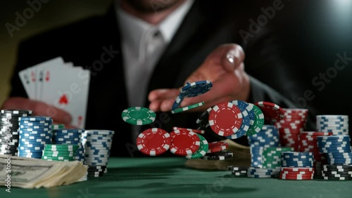 Poker player throwing poker chips on casino table in super slow motion, filmed on high speed cinema camera at 1000 fps. Gambling background. photo