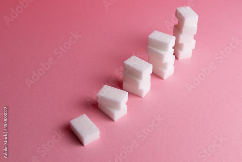 sugar cubes in piles on a pink background