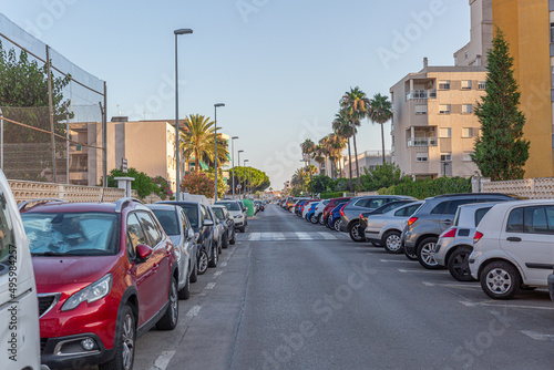 Street of a tourist town crowded with cars parked on the sides