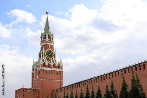 Red square in Moscow with Kremlin tower, chimes and brick wall on cloudy sky background. Symbol of Russian authorities