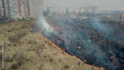Forest and field fire. Dry grass burns, natural disaster. Aerial view. Strong fire in an empty field, strong smoke from a burning place. Flying over a fire at low altitude.