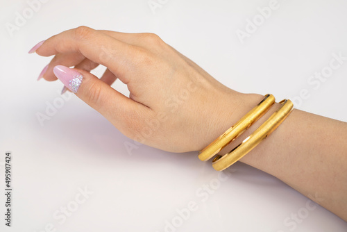 Graceful golden bracelets isolated on woman hand