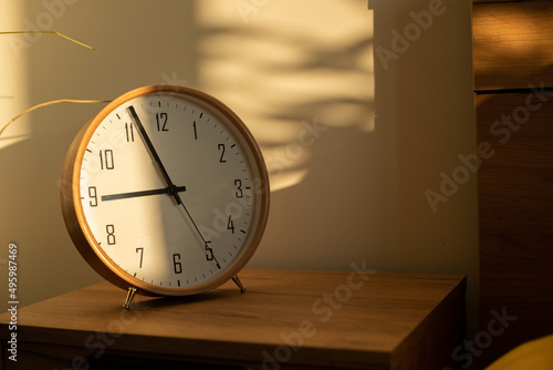 Sunshine on wooden clock in bedroom at morning 