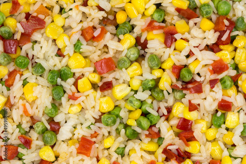 A mixture of rice and vegetables cooked in a frying pan for lunch. Vegetarian food.