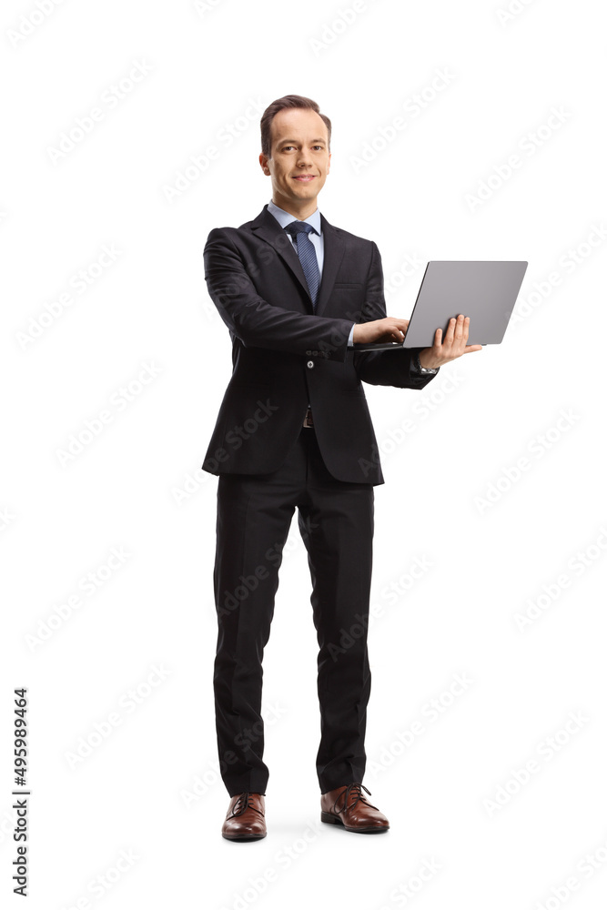 Full length portrait of a businessman holding a laptop computer and looking at camera Full length portrait of a businessman holding a laptop computer and looking at camera