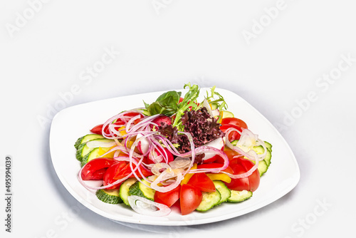 Vegetable salad of tomatoes, cucumbers, lettuce leaves, radishes, with olive oil