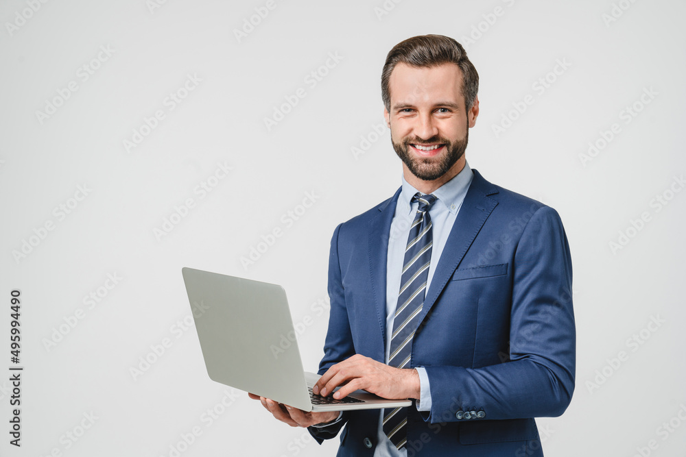 Successful young confident businessman using laptop for e-learning, remote work, watching webinar application online isolated in white background Successful young confident businessman using laptop for e-learning, remote work, watching webinar application online isolated in white background