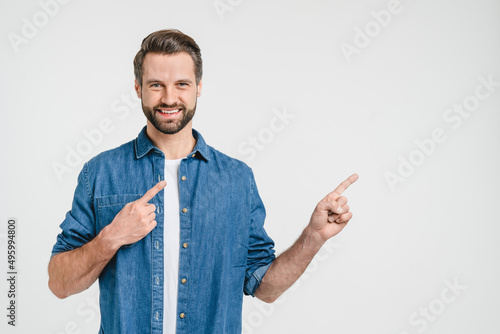 Bild auf Leinwand Happy smiling caucasian man freelancer student in denim clothes pointing showing