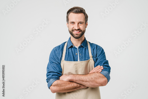Confident smiling caucasian young man student bartender barista in apron with arms crossed looking at camera isolated in white background. Takeaway food photo