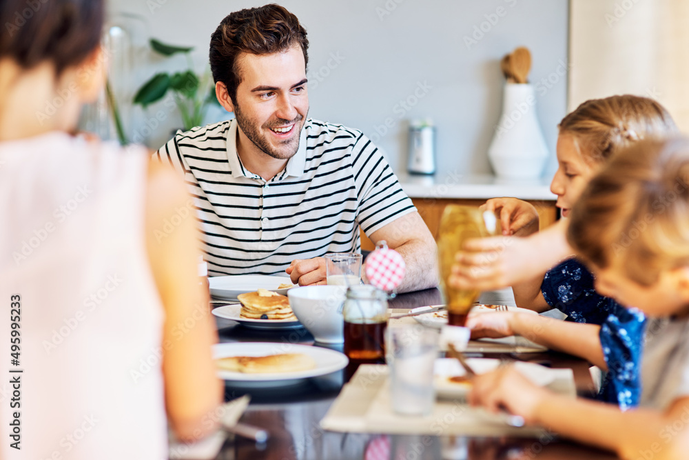 Theyre thoroughly enjoying their meal together. Shot of a family having breakfast together at home. Theyre thoroughly enjoying their meal together. Shot of a family having breakfast together at home.