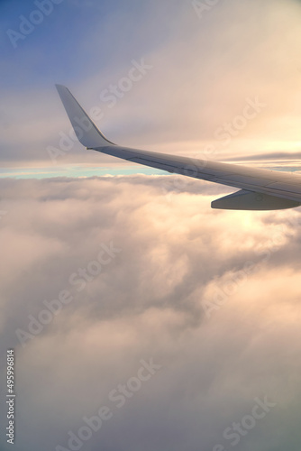 Obraz na płótnie Flying and traveling. View of airplane wing during sunset. Plane over clouds in the sky. w salonie