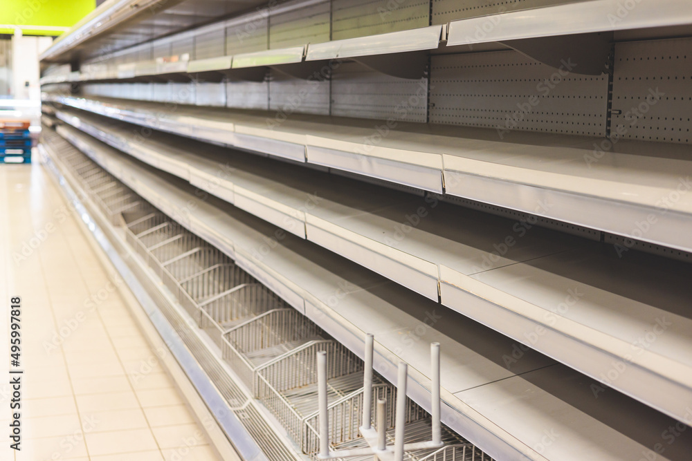 View of empty supermarket shelves, grocery store work stoppage closes, sanctions and embargo, panic buying with supplies and goods shortage, food crisis and deficit concept View of empty supermarket shelves, grocery store work stoppage closes, sanctions and embargo, panic buying with supplies and goods shortage, food crisis and deficit concept