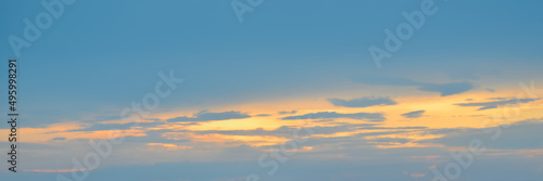 Beautiful evening sky in blue, yellow and orange colors. Sunset sky. Long banner