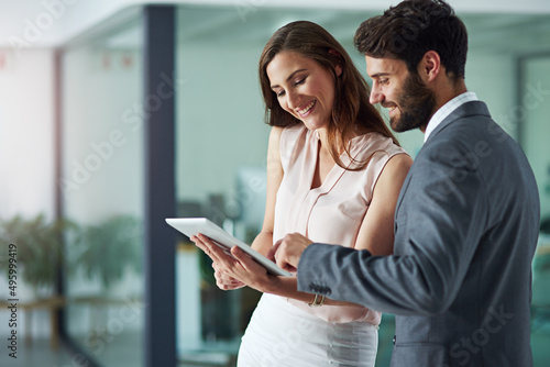 Positivity inspires productivity. Shot of a young businessman and businesswoman using a digital tablet together in an office.