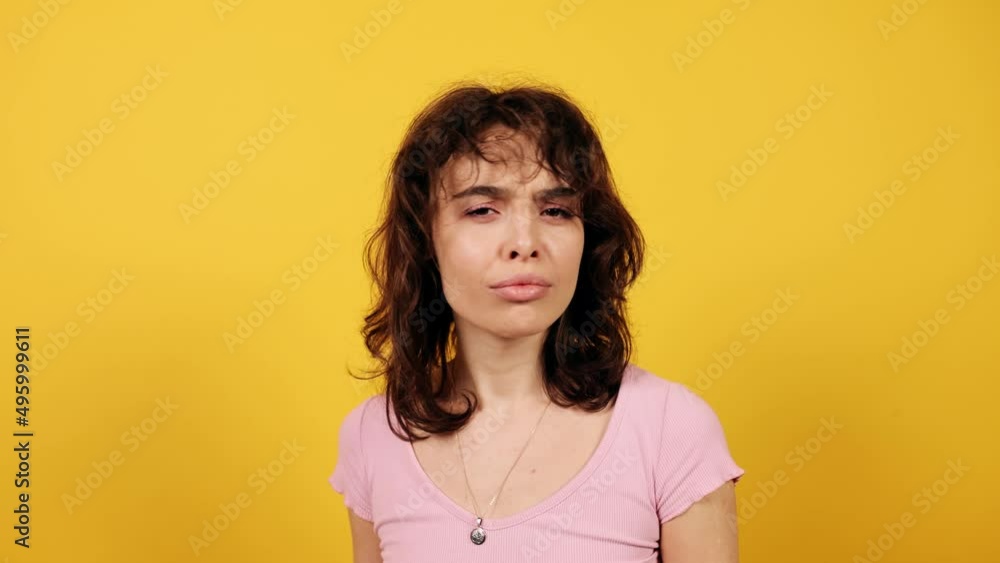 Young shocked surprised woman showing thumbs up. Attractive young girl on yellow background. Wow emotion. High quality 4k footage Young shocked surprised woman showing thumbs up. Attractive young girl on yellow background. Wow emotion. High quality 4k footage