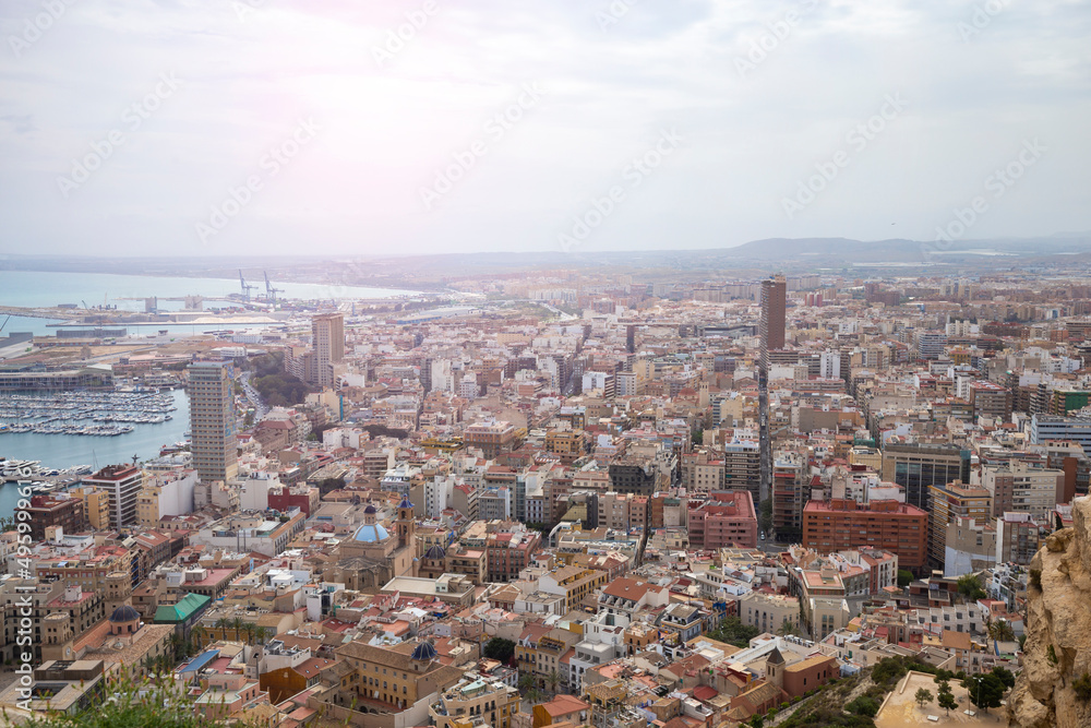Wide angle view of the modern city of Alicante, Spain. Panoramic view of the city with houses, skyscrapers, churches and a harbor with yachts