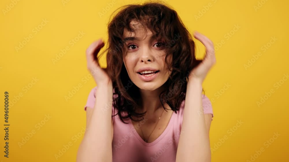 Girl looking at the camera as a mirror and sending a kiss. Attractive young girl on yellow background. High quality 4k footage Girl looking at the camera as a mirror and sending a kiss. Attractive young girl on yellow background. High quality 4k footage