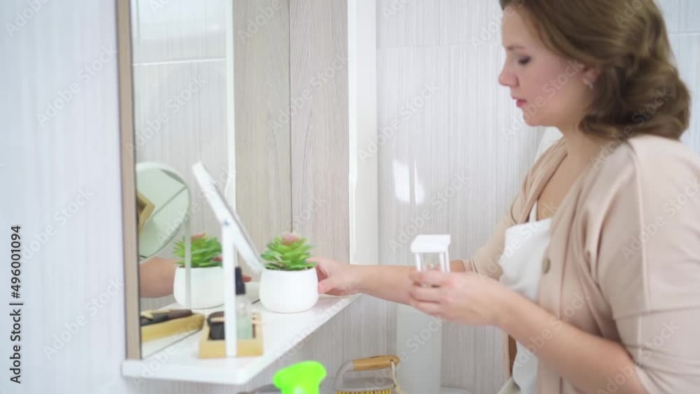 an attractive housewife washes the sink and bathroom mirror an attractive housewife washes the sink and bathroom mirror