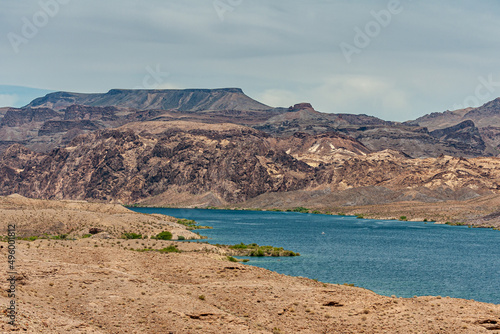 Photography Nelson, Nevada, USA - May 21, 2011: Blue Colorado river with Arizona and Nevada shore lines under light blue cloudscape, Dry desert with rocky hills on both sides