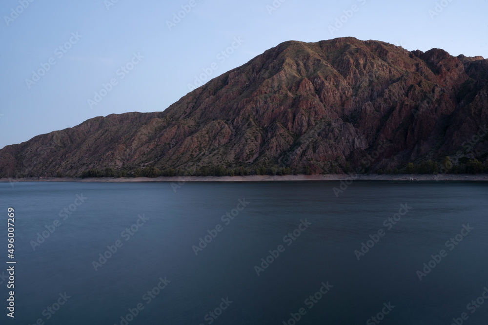 Long exposure shot of the lake and mountains at nightfall. Beautiful blurred water effect and color. 