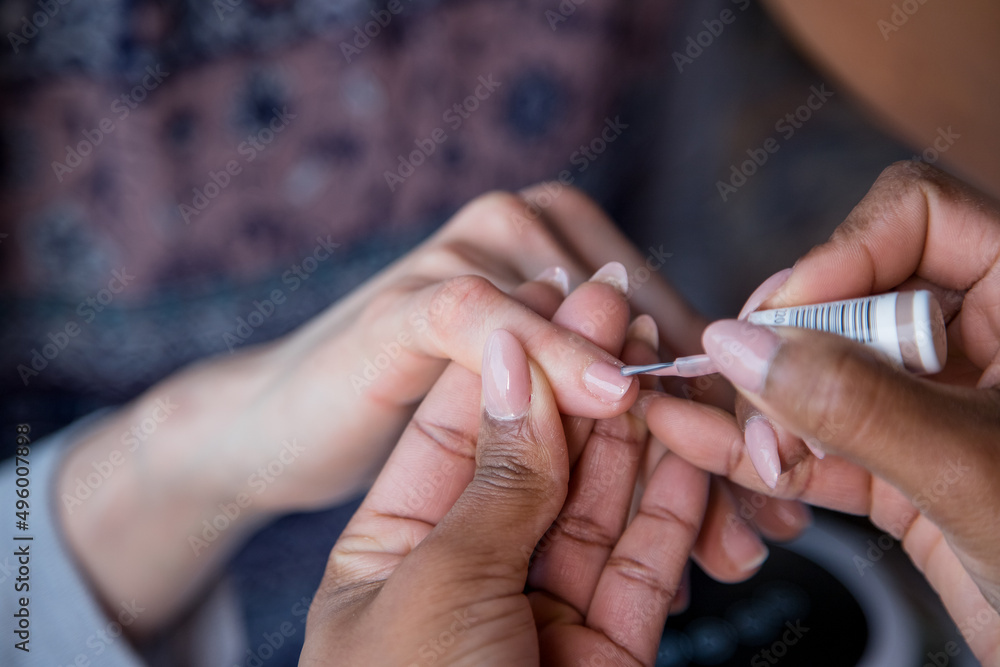 Woman taking care of her nails with a manicure service. Hands of a person with a manicure. Process steps