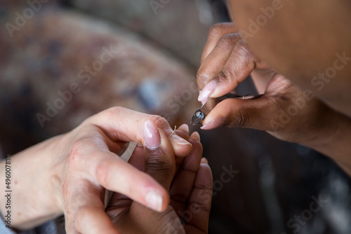 Woman taking care of her nails with a manicure service. Hands of a person with a manicure. Process steps