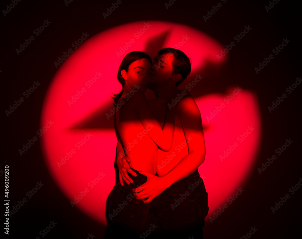 the shadow of the silhouette of a rocket bomb on a pair of peaceful young people on a red background threatens life during the war the shadow of the silhouette of a rocket bomb on a pair of peaceful young people on a red background threatens life during the war