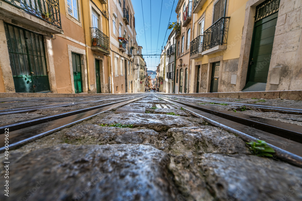 Tram tracks at the narrow street in the Lisbon, a detail metal rails for the tram
