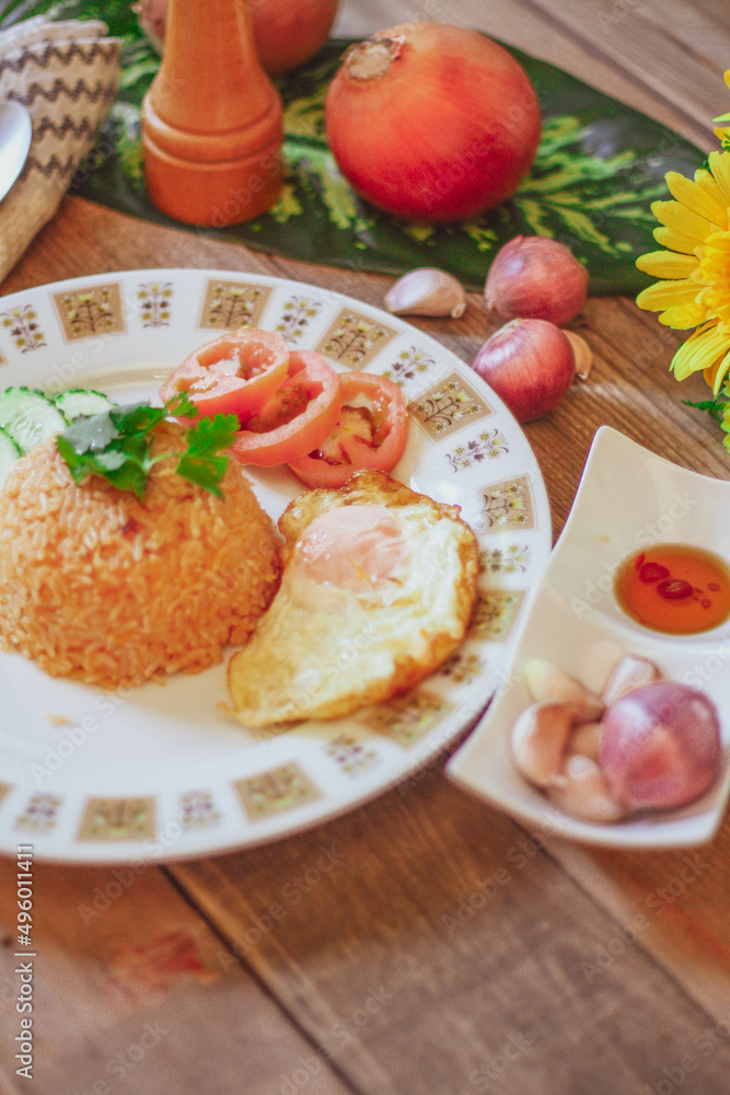 Fried Rice with Fried Egg Put on the wooden table and the tomatoes, cucumbers, garlic, shallots Fried Rice with Fried Egg Put on the wooden table and the tomatoes, cucumbers, garlic, shallots
