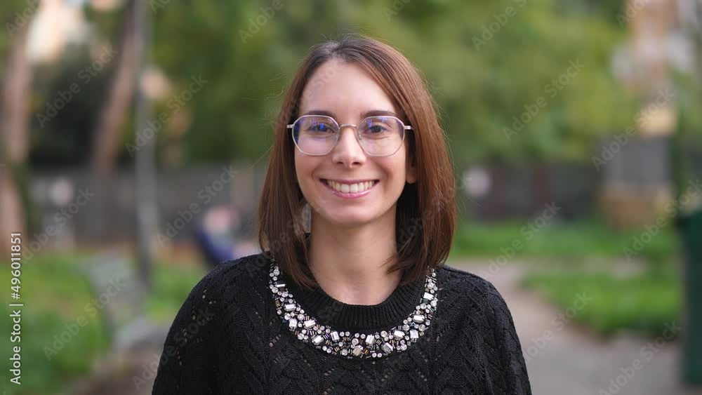 Portrait of attractive young cute woman smiling at camera. Cute girl smiles into the camera: outdoor portrait Portrait of attractive young cute woman smiling at camera. Cute girl smiles into the camera: outdoor portrait