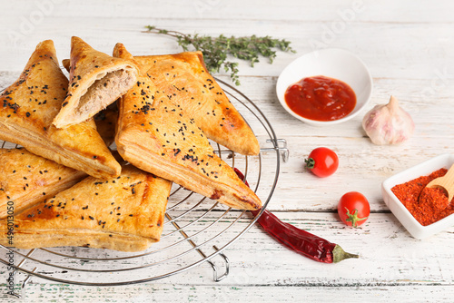 Cooling rack with tasty Uzbek samsa on table photo