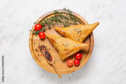 Tray with tasty Uzbek samsa on white background photo