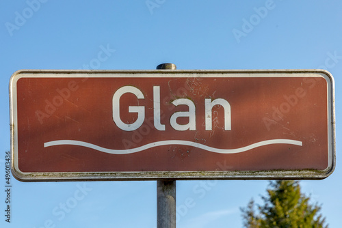 sign river Glan under blue sky with wave symbol and brown color photo