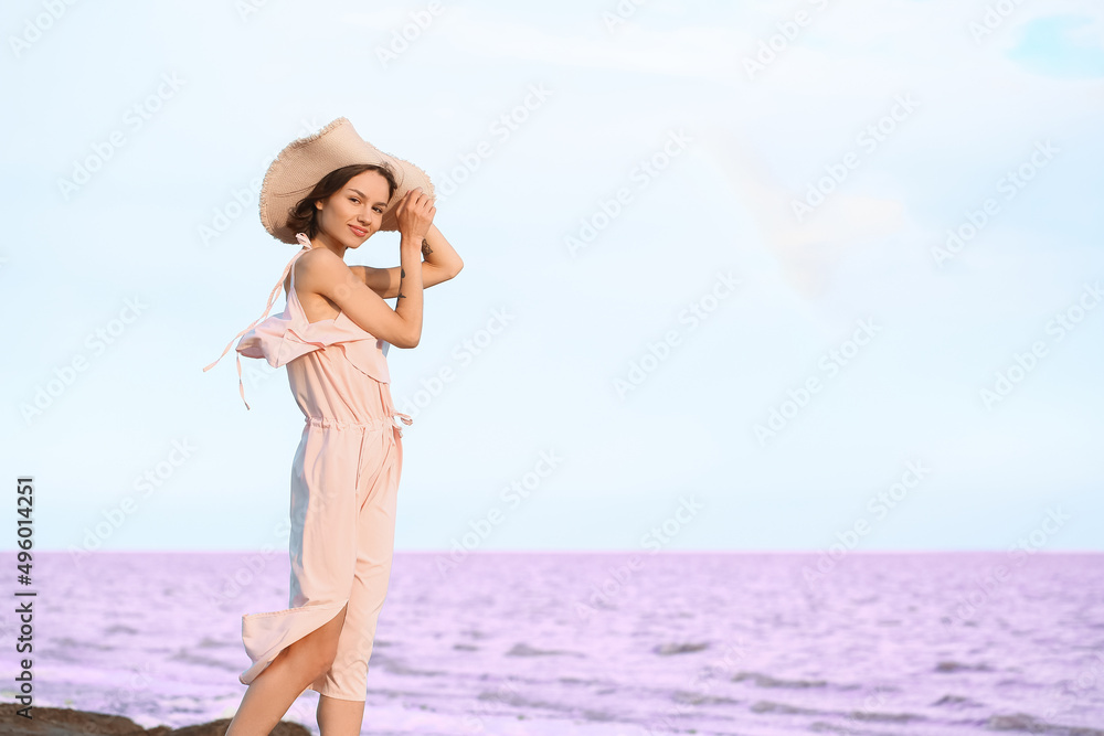 Stylish young woman posing near pink lake on summer day Stylish young woman posing near pink lake on summer day