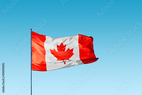 Waving flag of Canada against blue sky